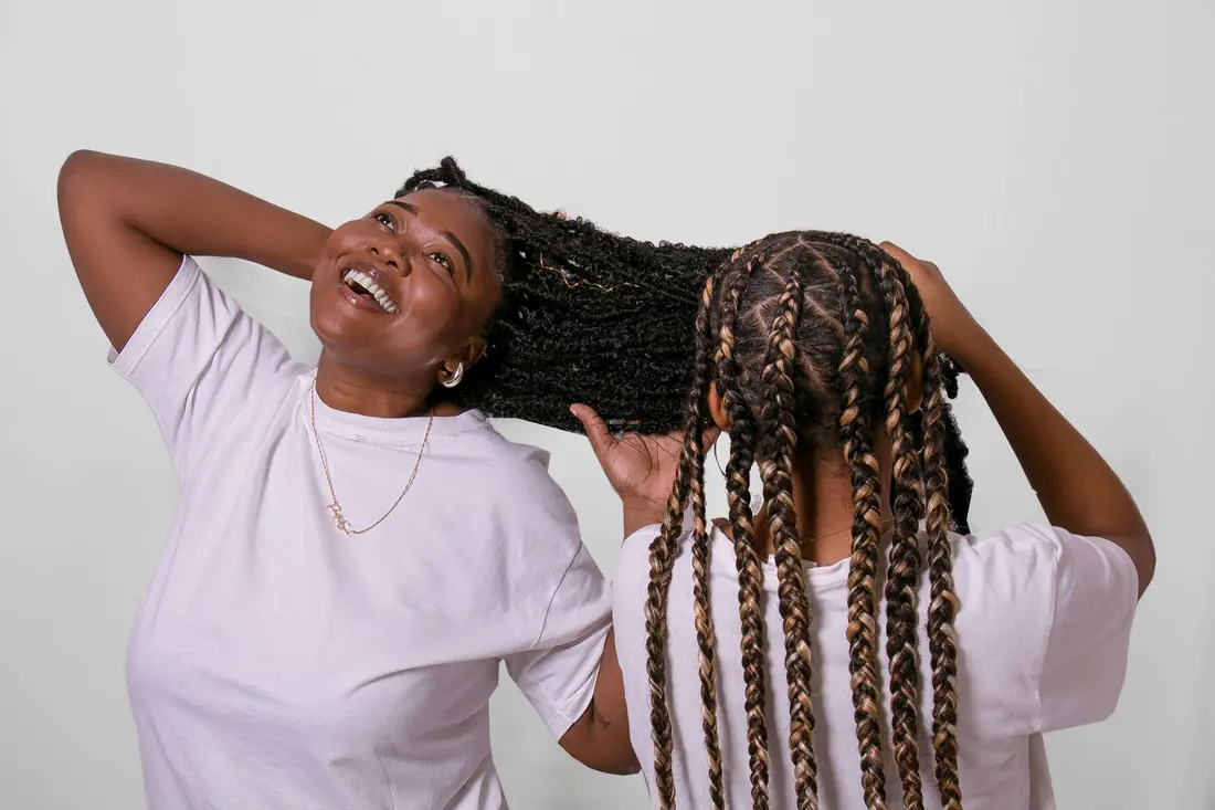 Braiders working efficiently on a client’s hair